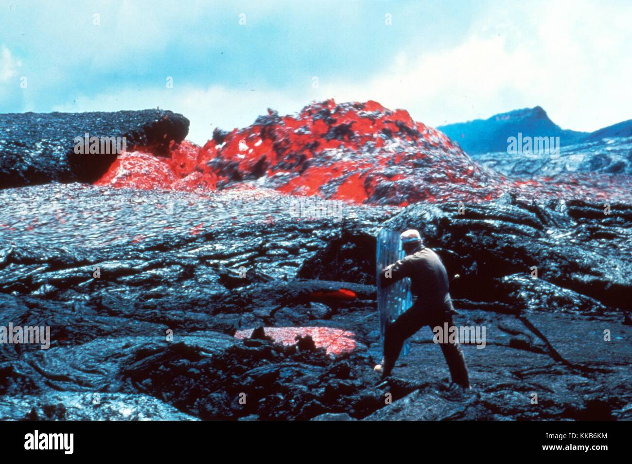 In Hawaii Volcanoes National Park, Ed Wolfe takes a temperature measurement on a sluggish channel eddy on Mt Kilauea which had begun erupting in 1983. Image courtesy P.W. Lipman/USGS. March 31, 1984. Stock Photo