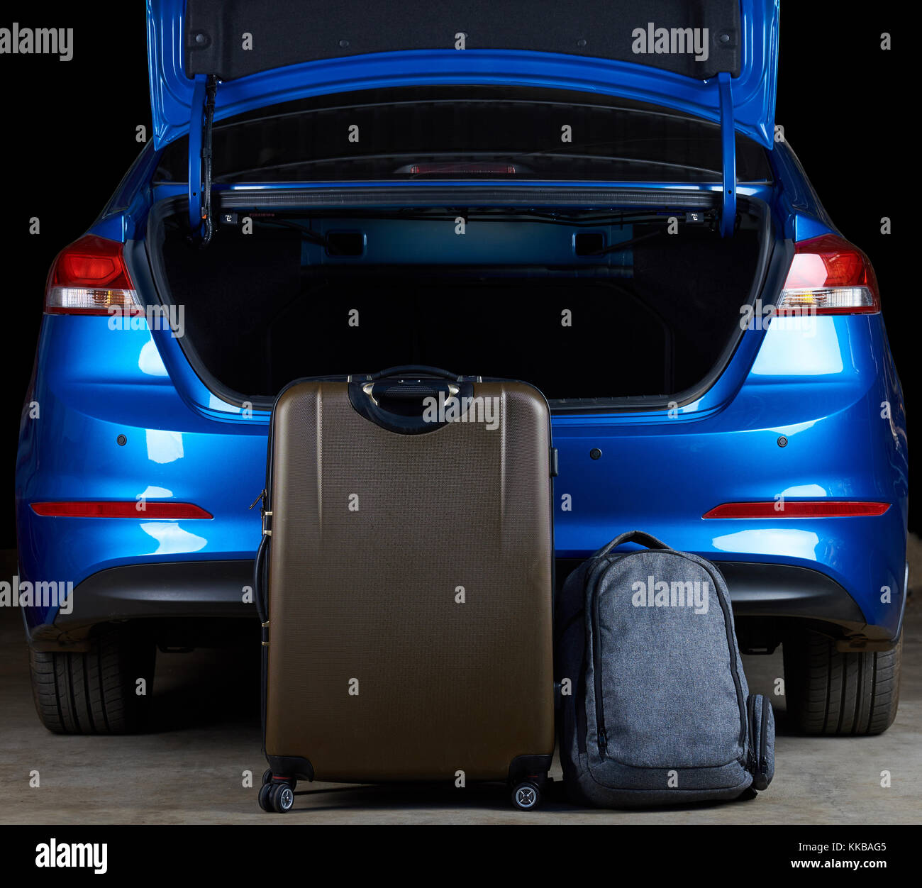 Filling modern car trunk with bags. Loading empty blue car trunk Stock Photo