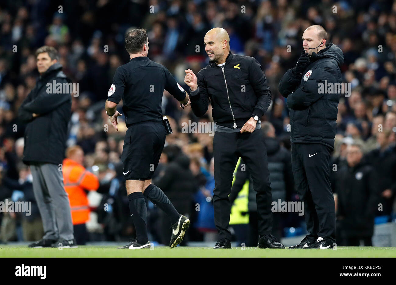 Manchester City manager Pep Guardiola (centre) is spoken to by referee Paul Tierney after his post-goal celebration following their second goal during the Premier League match at the Etihad Stadium, Manchester. Stock Photo