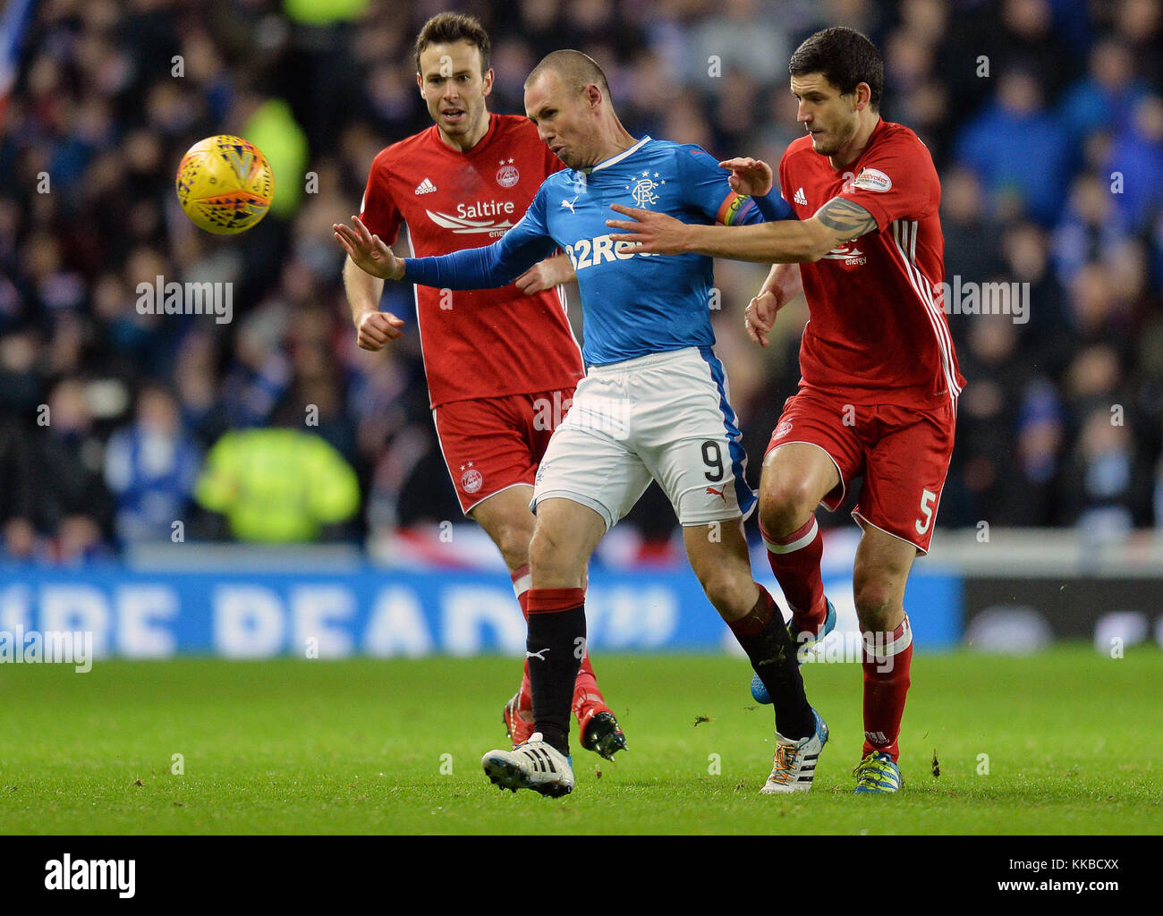 Aberdeen's Anthony O'Conner and Andy Considine challenge Rangers' Kenny Miller during the Ladbrokes Scottish Premiership match between Rangers and Aberdeen at the Ibrox Stadium, Glasgow. Stock Photo