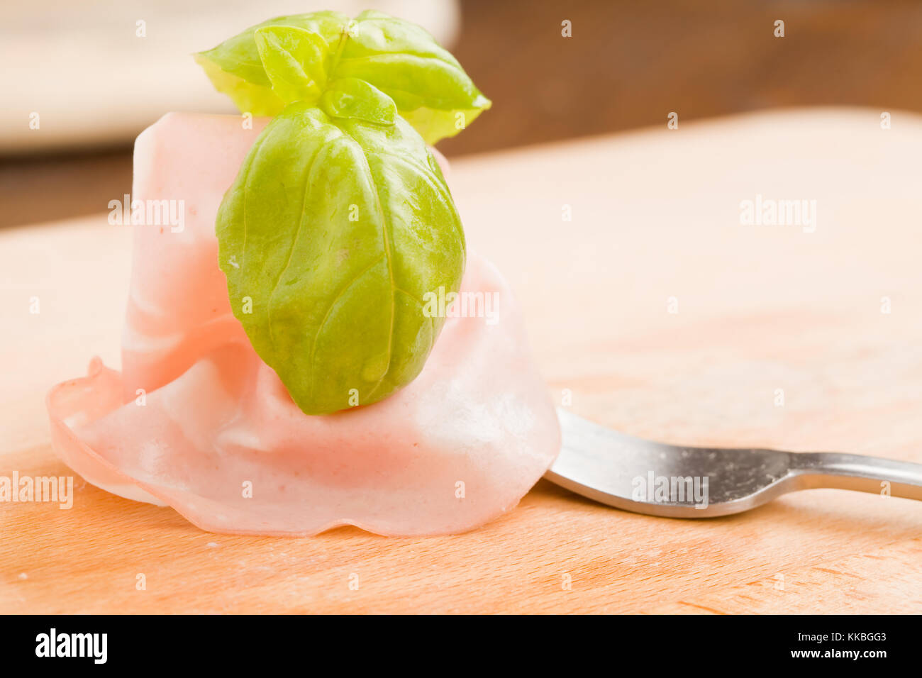 photo of delicious italian mortadella ham with basil leaf Stock Photo