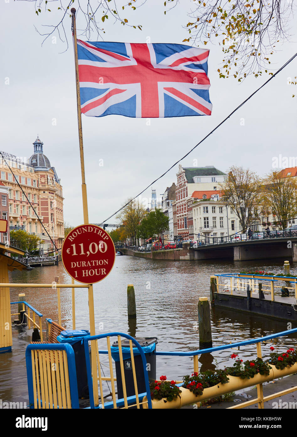 Union Jack flying next to sign for Canal trip, Amsterdam, Holland Stock Photo