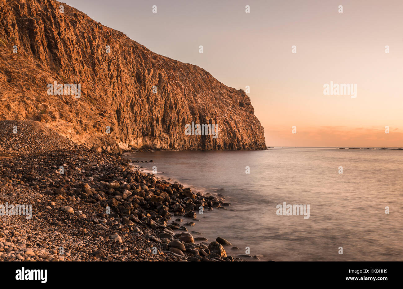 Peaceful evening at sunset on the seafront looking towards the cliffs at the eastern end of Los Cristianos, Tenerife, Canary Islands Stock Photo