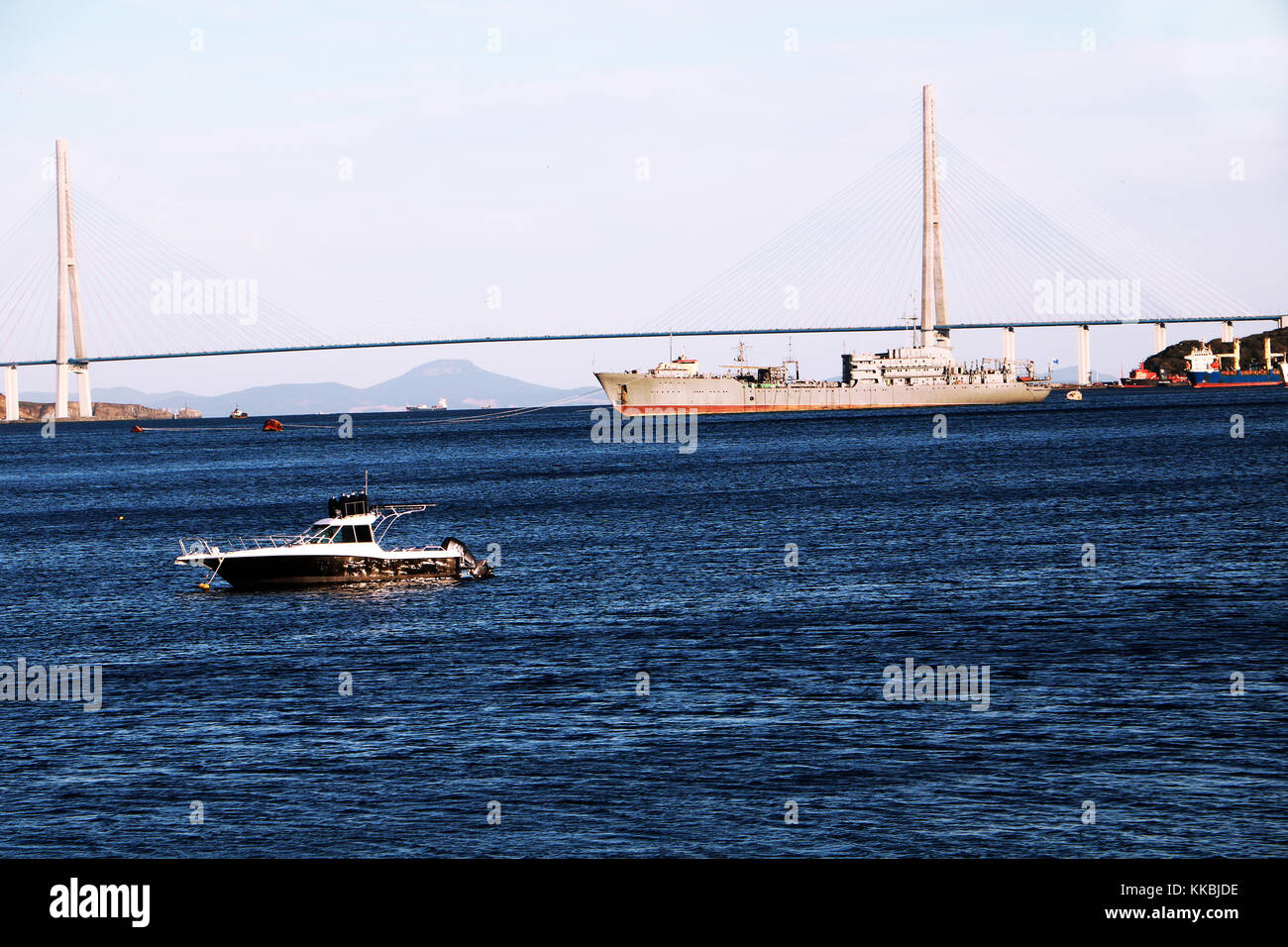 RUSSIA, VLADIVOSTOK, 27.09.20017. View on Golden bridge in Vladivostok city with a ship and little yacht in the bay. Stock Photo