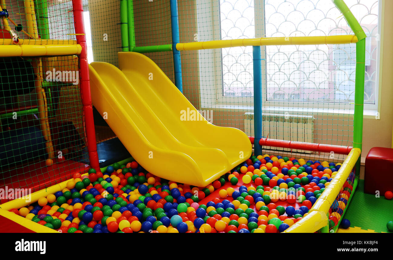 Yellow Baby Slide Going Down To The Pool With Many Colored Balls In The Kids Playing Room Stock Photo Alamy