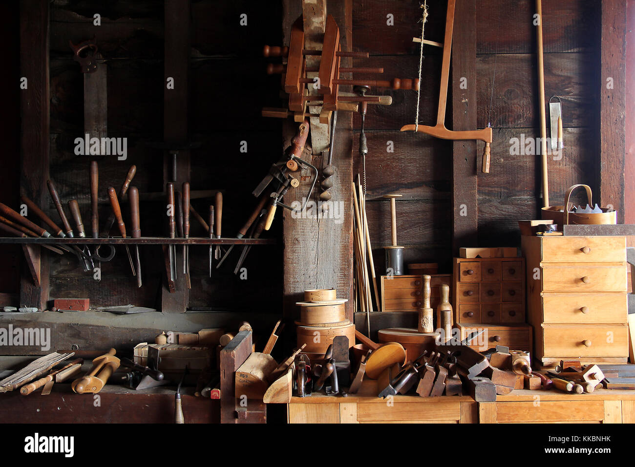 Old tools workshop with saws, planes, chisels, hammers, and sets of drawers. Stock Photo