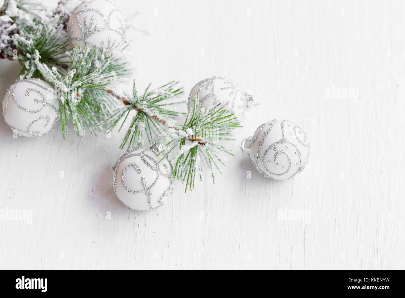 Silver and white Christmas ornaments with snowy fir tree branch Stock ...
