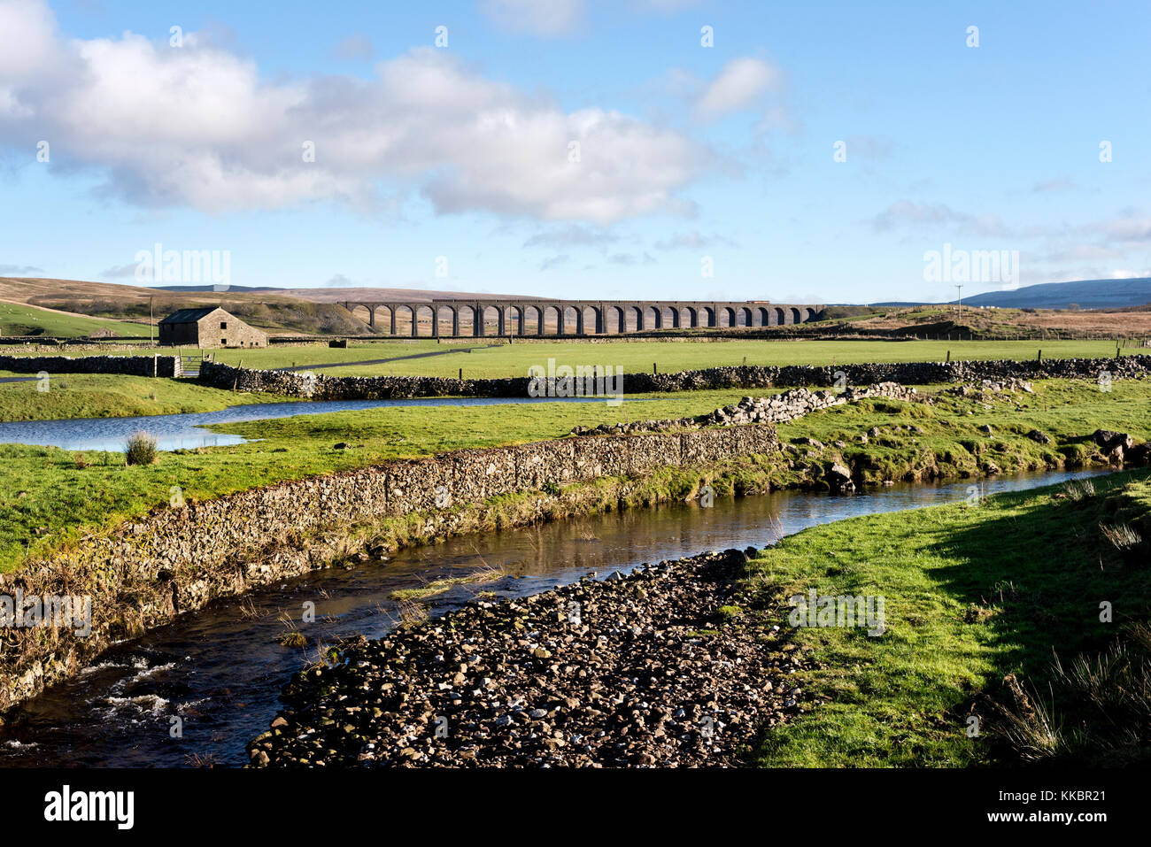 A minerals freight train crosses Ribblehead viaduct, Near Ingleton, North Yorkshire, in the Yorkshire Dales National Park,UK Stock Photo