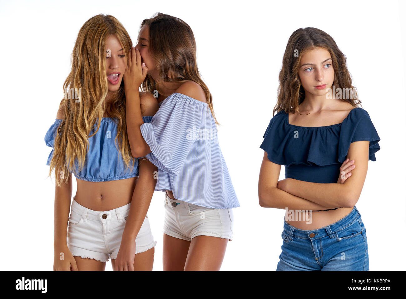 Teen best friends bullying a girl sad apart out of the game on white background Stock Photo