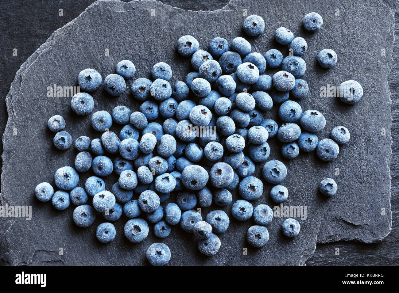 Frozen blueberry on black slate. Close up. Top view. High resolution product. Stock Photo