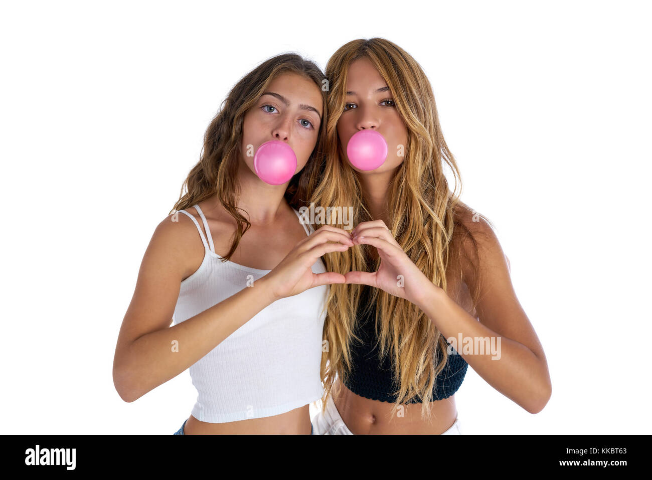 Best friends teen girls with bubble gum and heart fingers shape gesture Stock Photo