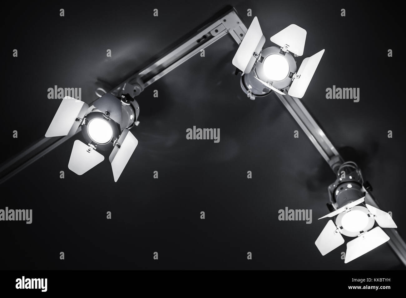 Three spot lights in metal body over black ceiling background, stage illumination equipment Stock Photo