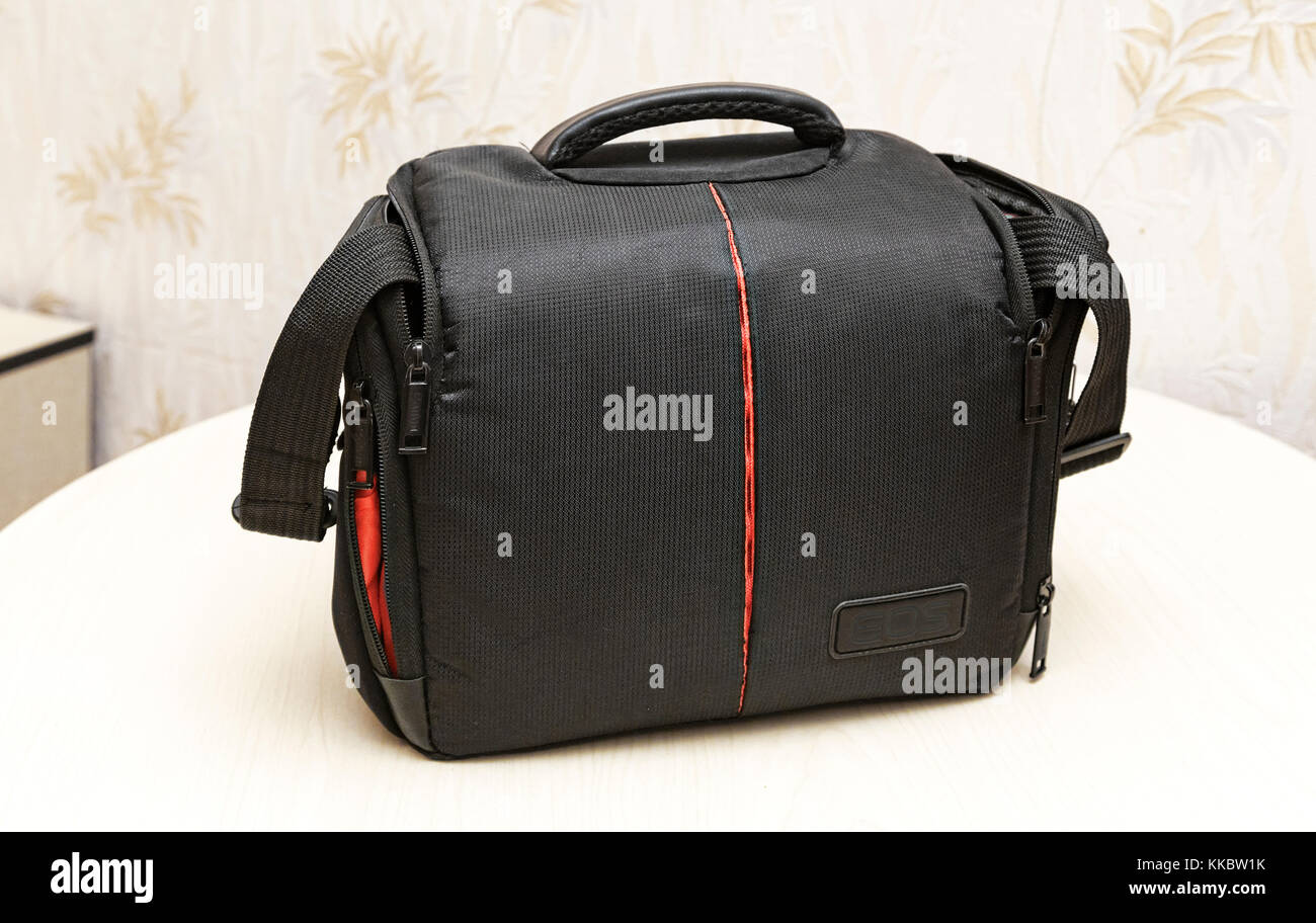 On the table a black camera bag with compartments for accessories Stock