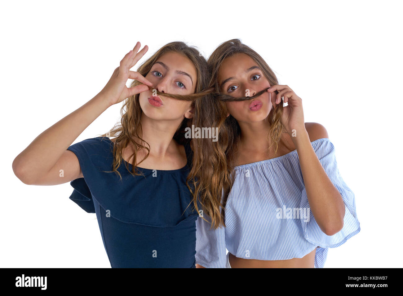 Teen best friends girls having fun doing moustache with hair Stock Photo