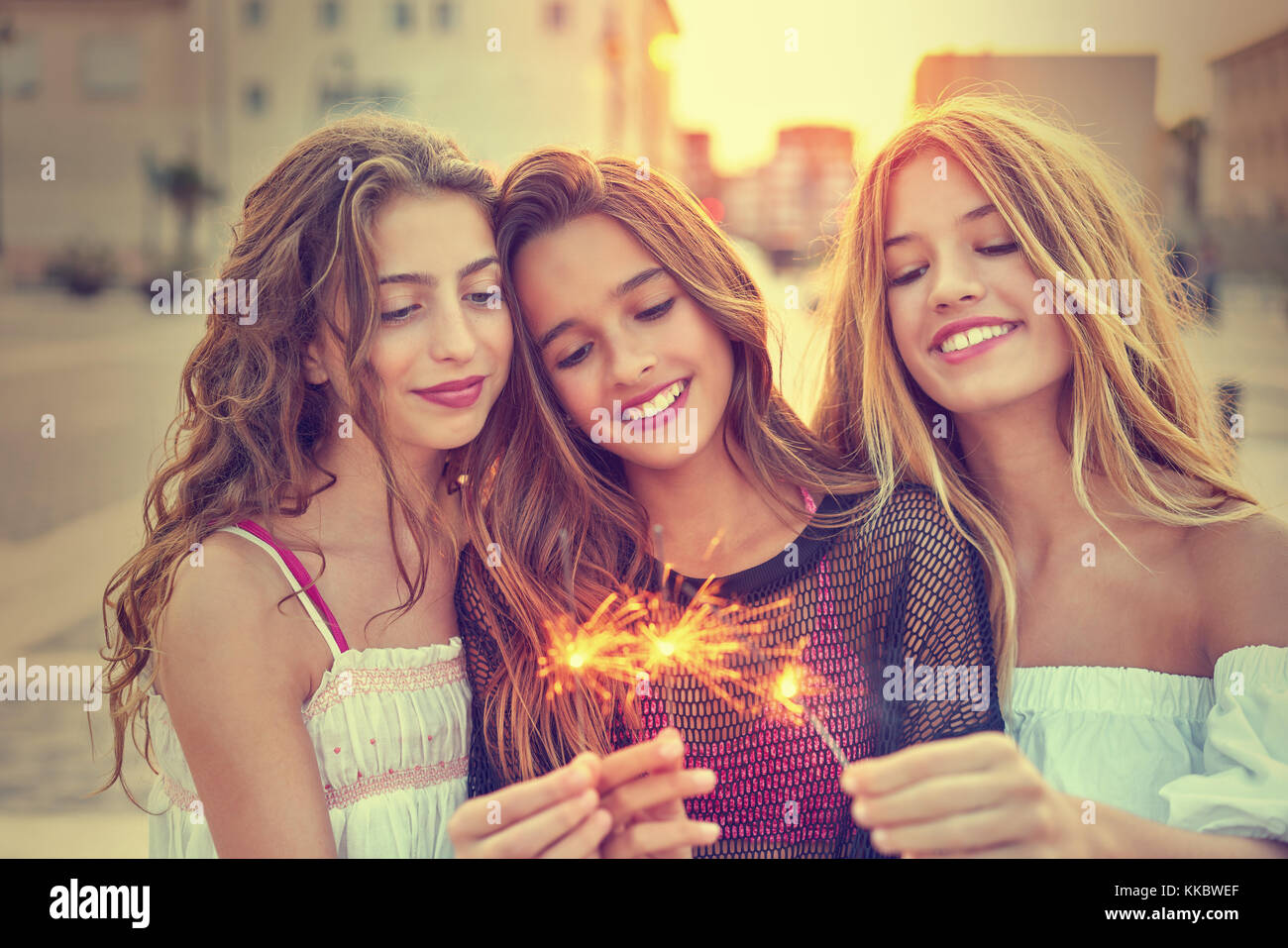 Best friends teen girls with sparklers at sunset in the city filtered image Stock Photo