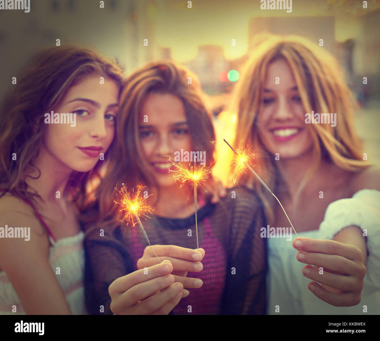 Best friends teen girls with sparklers at sunset in the city filtered image Stock Photo