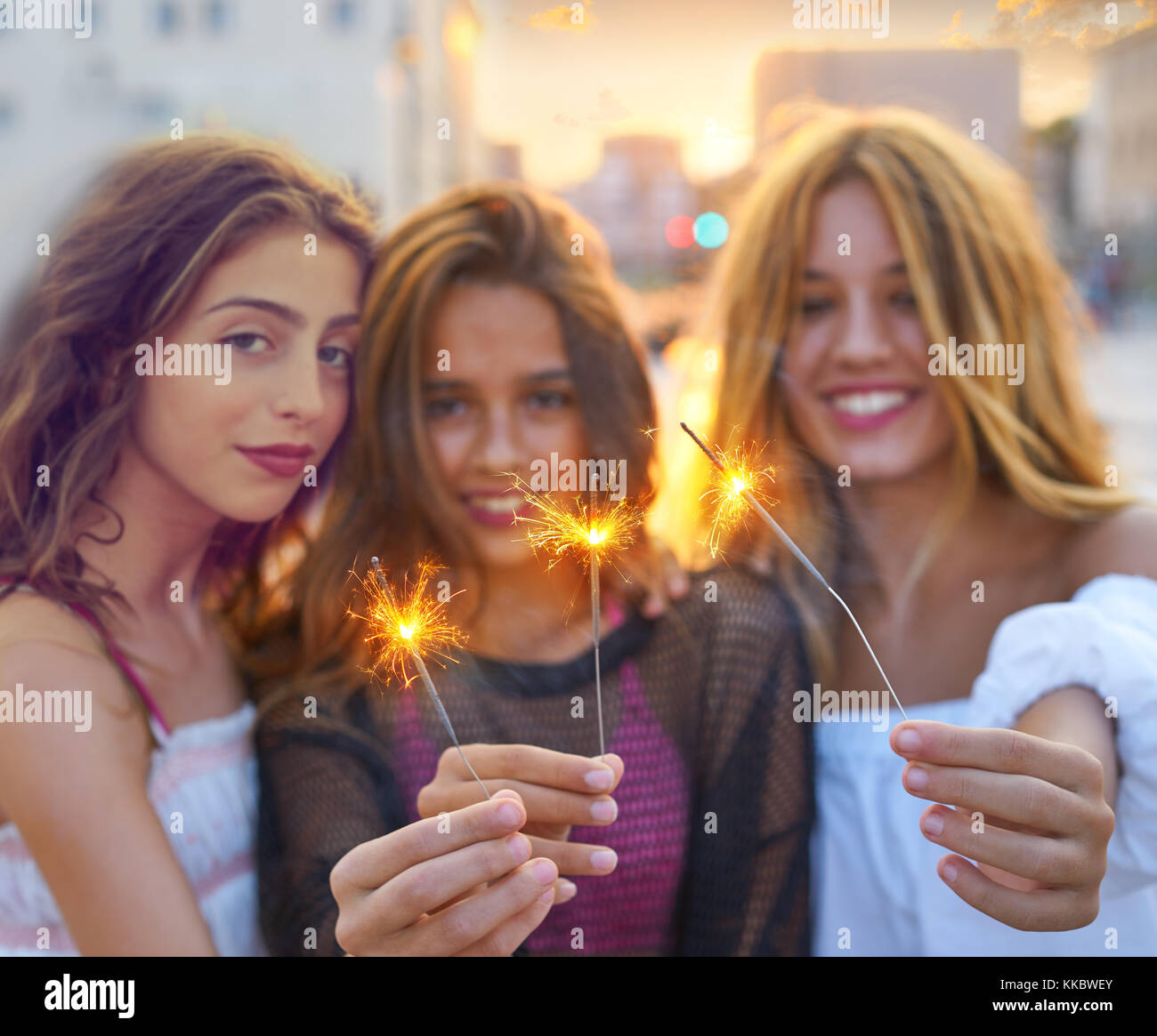 Best friends teen girls with sparklers at sunset in the city Stock Photo