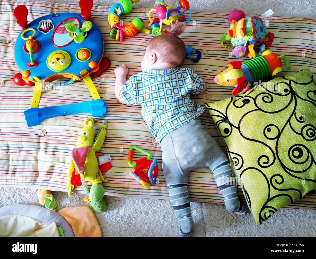 Cute newborn baby sleeping among toys on the floor. Stock Photo