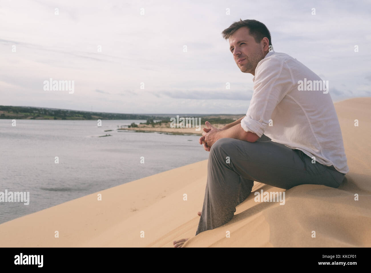 Man sitting alone on the beach hi-res stock photography and images - Alamy