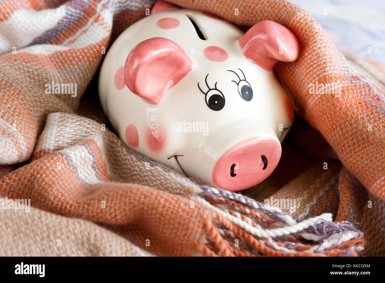 economy and finance - piggi bank in a warm scarf - heating expenses for household Stock Photo