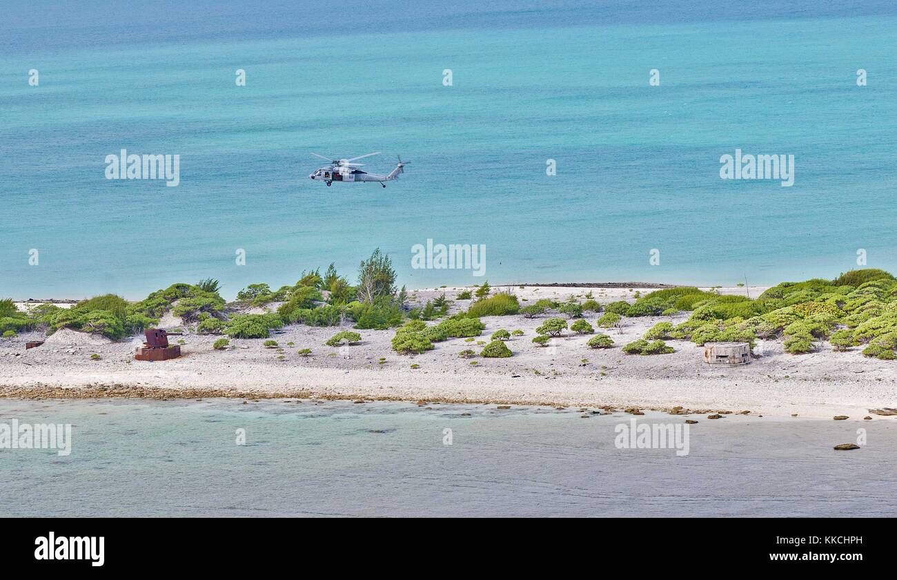 An MH-60S Sea Hawk helicopter assigned to the Blackjacks of Helicopter Sea Combat Squadron HSC 21 flies over Wake Island during practice flight operations, Wake Island. Image courtesy Mass Communication Specialist 3rd Class Michael Feddersen/US Navy. 2012. Stock Photo
