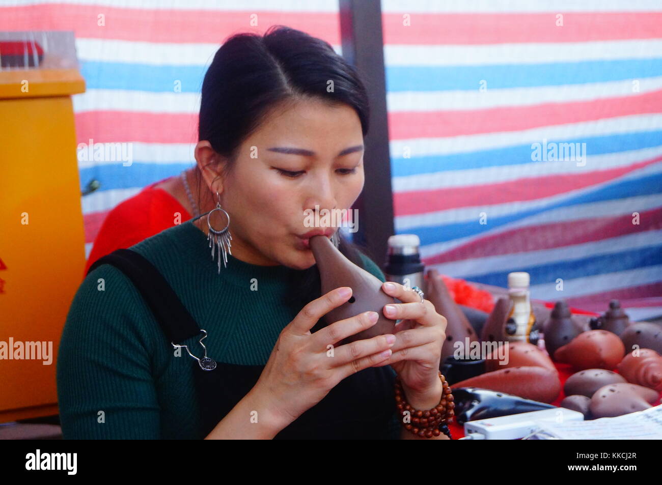 A young woman was playing an old musical instrument with her mouth ...
