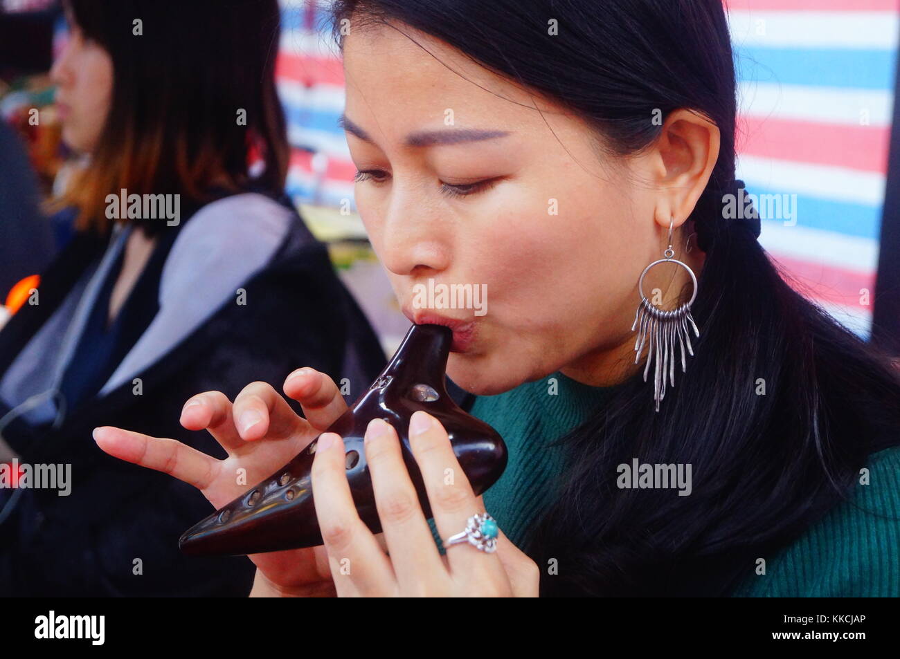 A young woman was playing an old musical instrument with her mouth ...