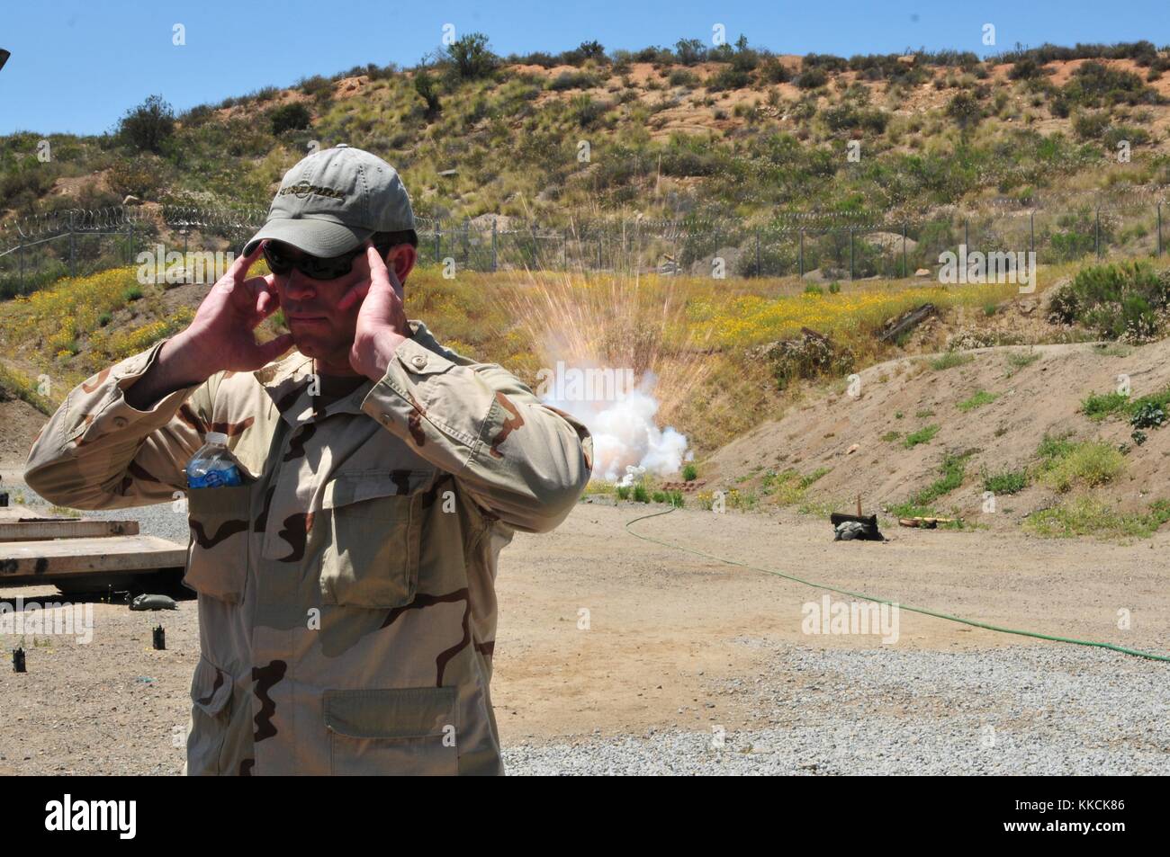 Explosive Ordnance Disposal EOD Chief Donovan Trost, assigned to Platoon 371, Mobile Unit Three, protects his face and ears after detonating a replica of an improvised explosive device IED during a training evolution, San Diego. Image courtesy Mass Communication Specialist Seaman Geneva G. Brier/US Navy, 2012. Stock Photo