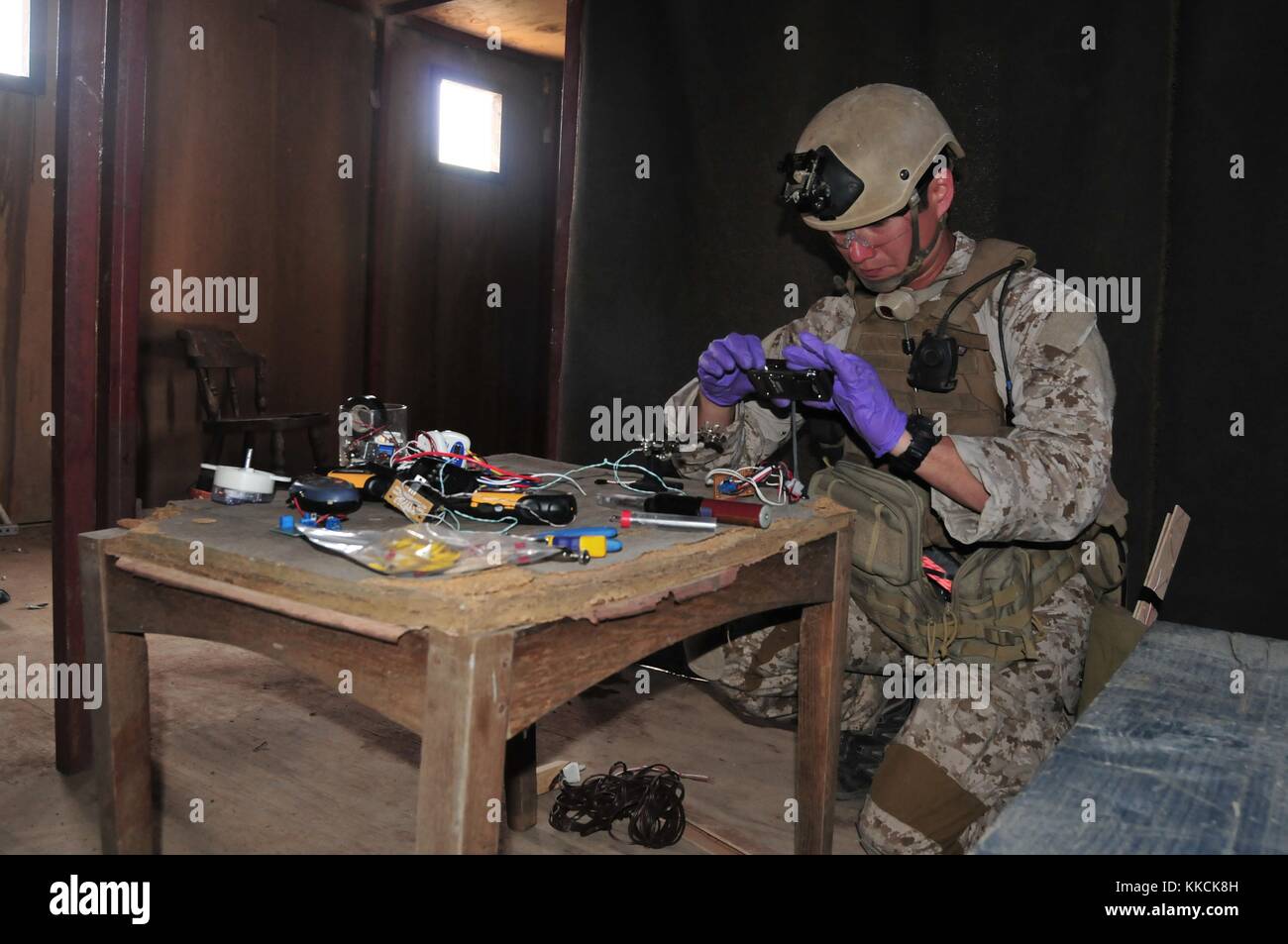 An explosive ordnance disposal EOD technician assigned to Platoon 371, Mobile Unit Three, photographs evidence found during Military Operations in Urban Terrain MOUT training, San Diego. Image courtesy Mass Communication Specialist Seaman Geneva G. Brier/US Navy, 2012. Stock Photo