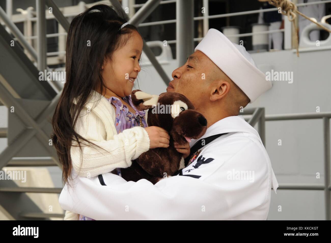 Logistics Specialist 2nd Class Roel Lunod, assigned to the Ticonderoga-class guided-missile cruiser USS Bunker Hill CG 52, receives the first hug from his daughter during a homecoming celebration at Naval Base San Diego. Image courtesy Mass Communication Specialist 2nd Class Rosalie Garcia/US Navy, 2012. Stock Photo