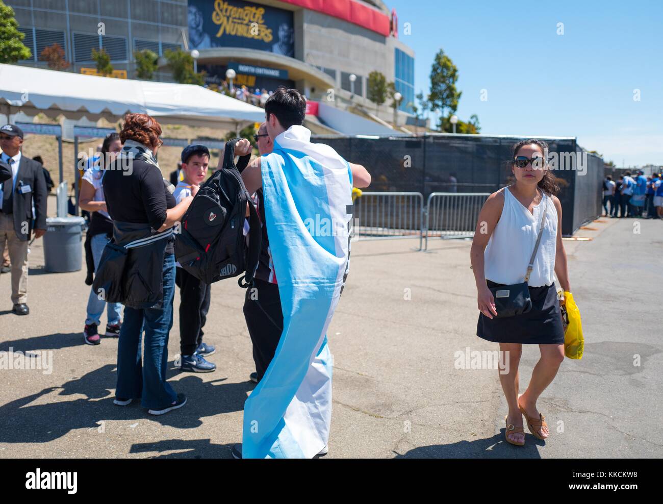 Before Game 2 of the National Basketball Association (NBA) Finals between the Golden State Warriors and the Cleveland Cavaliers, a fan of the Warriors wears a blue and white cape while approaching Oracle Arena in Oakland, California, June 5, 2016. Stock Photo
