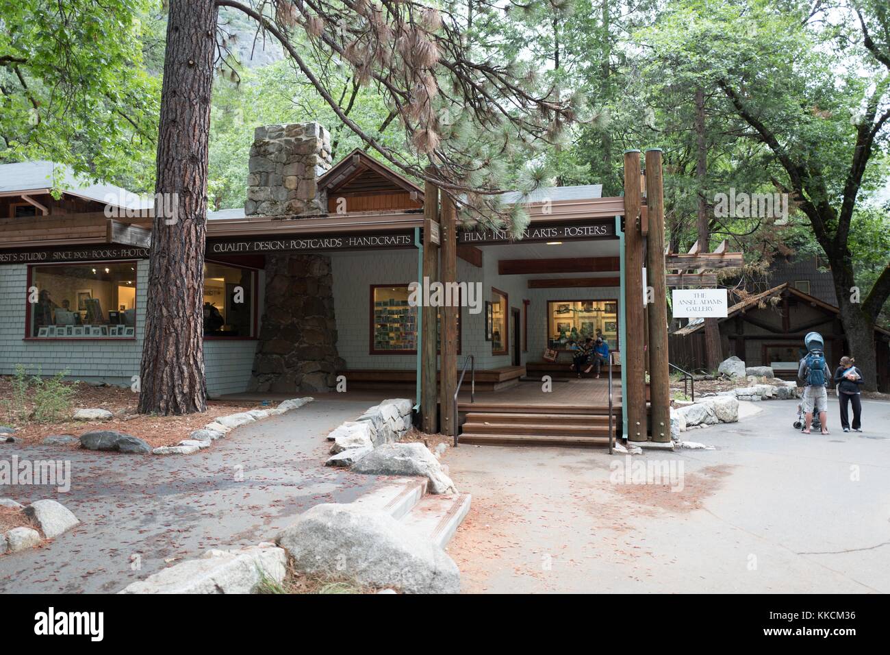Young family with a baby stroller standing in front of the Ansel Adams gallery in Yosemite Village at Yosemite National Park, Yosemite Valley, California, 2016. Stock Photo