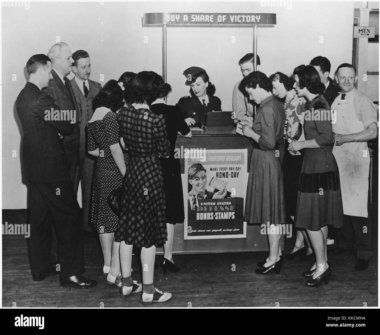 A young woman sells war bonds and stamps and distributes War Production Drive literature. ca. 1943. Image courtesy National Archives, 1943. Stock Photo