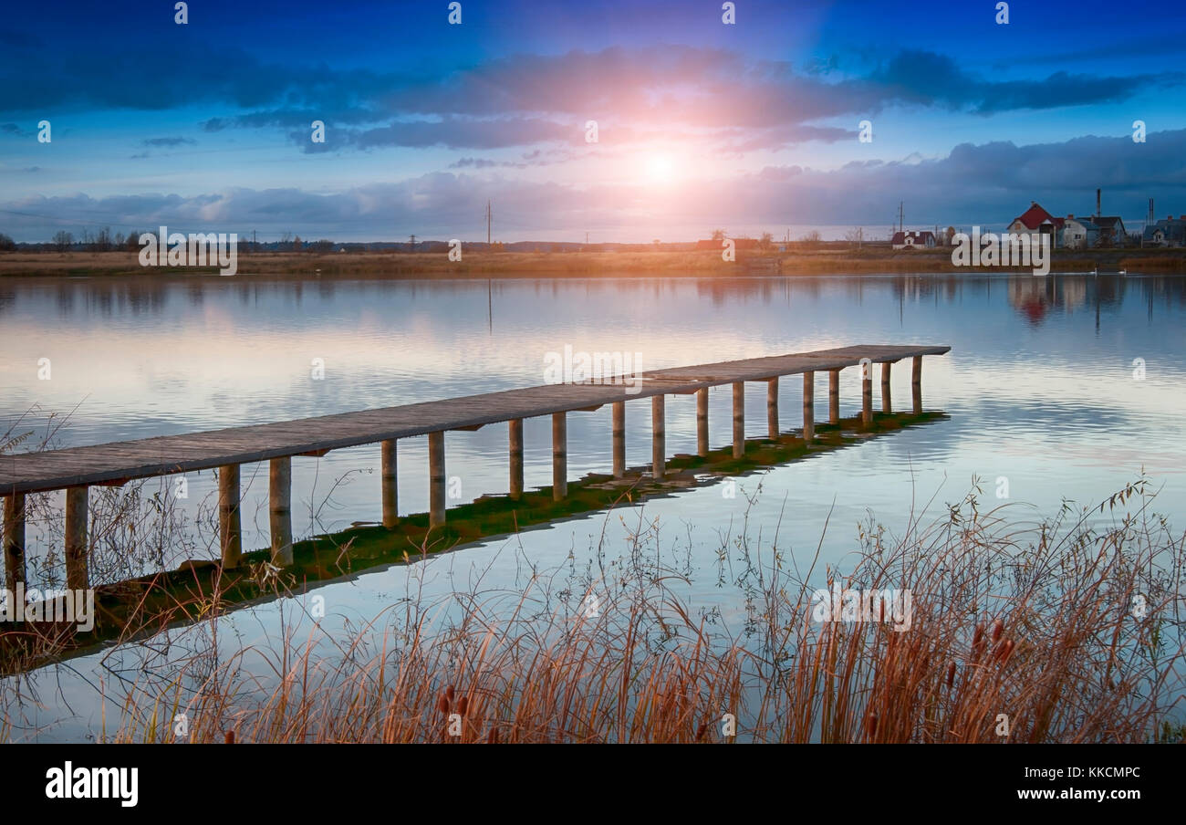 sunset on old wooden jetty at the lake Stock Photo
