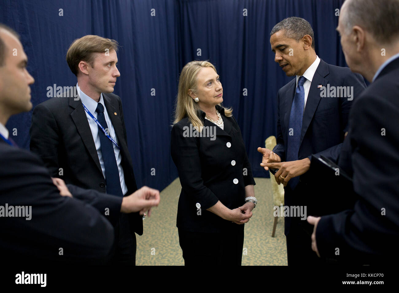 President Barack Obama talks with Secretary of State Hillary Rodham Clinton about his decision to send her to the Middle East while attending the U.S.-ASEAN Summit in Phnom Penh, Cambodia, Nov. 20, 2012. From left are: Ben Rhodes, Deputy National Security Advisor for Strategic Communications; Jake Sullivan, Deputy Chief of Staff to the Secretary of State; and National Security Advisor Tom Donilon. (Official White House Photo by Pete Souza)  This official White House photograph is being made available only for publication by news organizations and/or for personal use printing by the subject(s)  Stock Photo