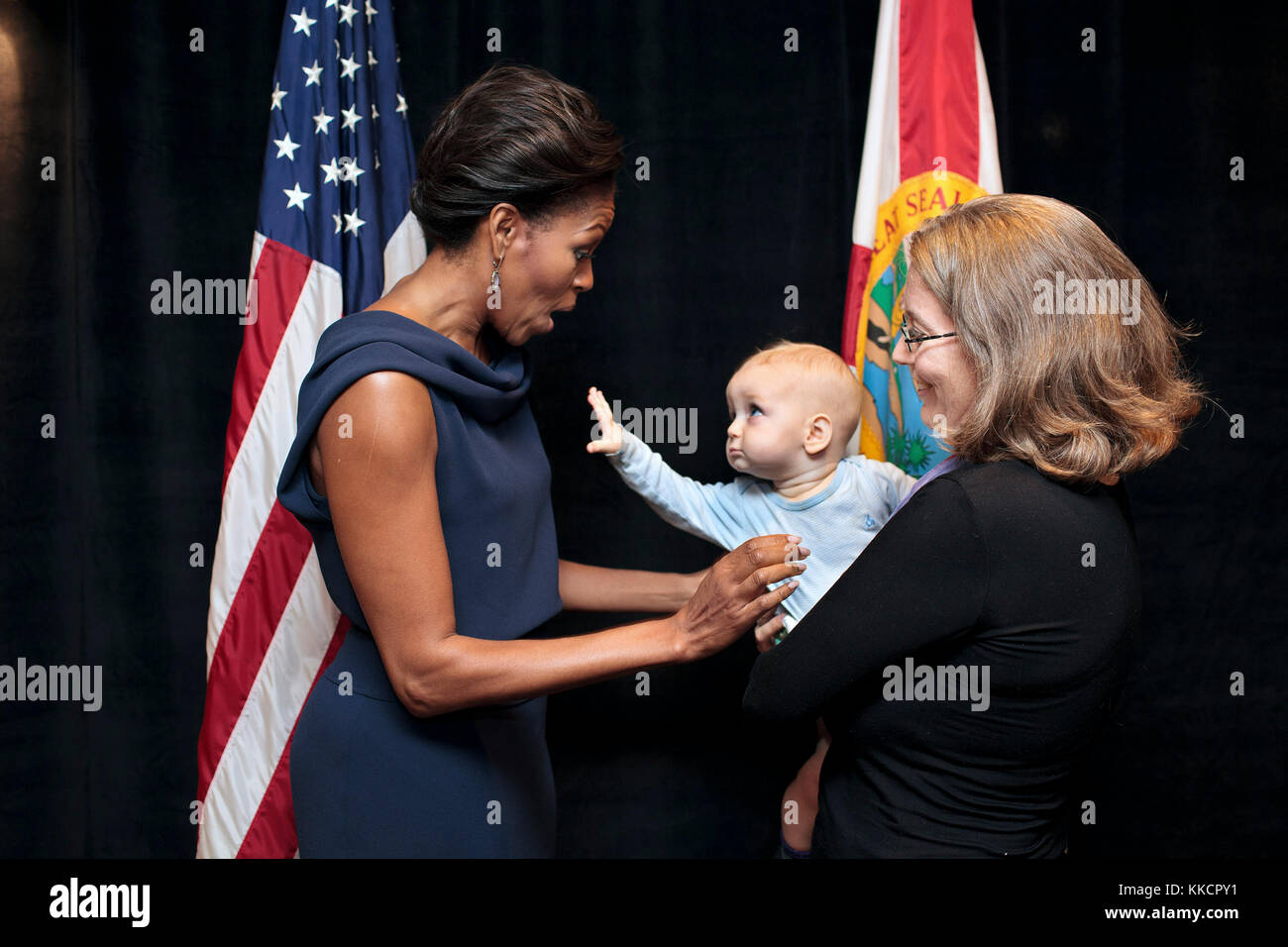 A child reaches out to First Lady Michelle Obama prior to a Faith and Community Groups Leading the Way event at Northland, A Church Distributed, in Longwood, Fla., Feb. 11, 2012. The event was held  in celebration of the second anniversary of the 'Let's Move!' initiative. Stock Photo