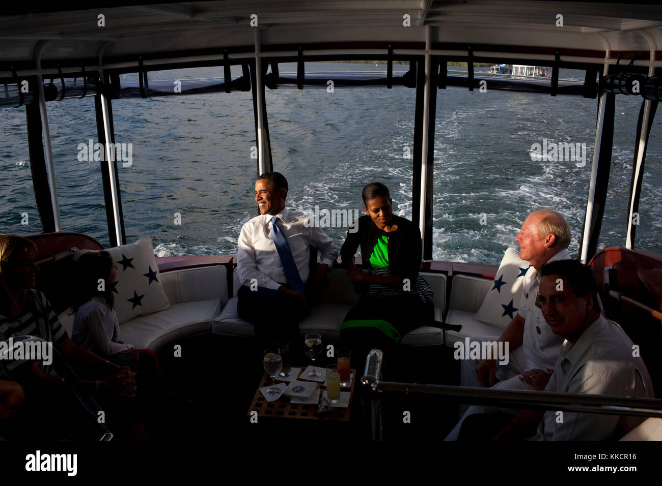 President Barack Obama and First Lady Michelle Obama talk with Admiral Robert Willard, Commander, U.S. Pacific Command, and his family, aboard the Admiral's barge CINCPACFLT while en route to the USS Arizona Memorial in Pearl Harbor, Hawaii, Dec. 29, 2011. Stock Photo
