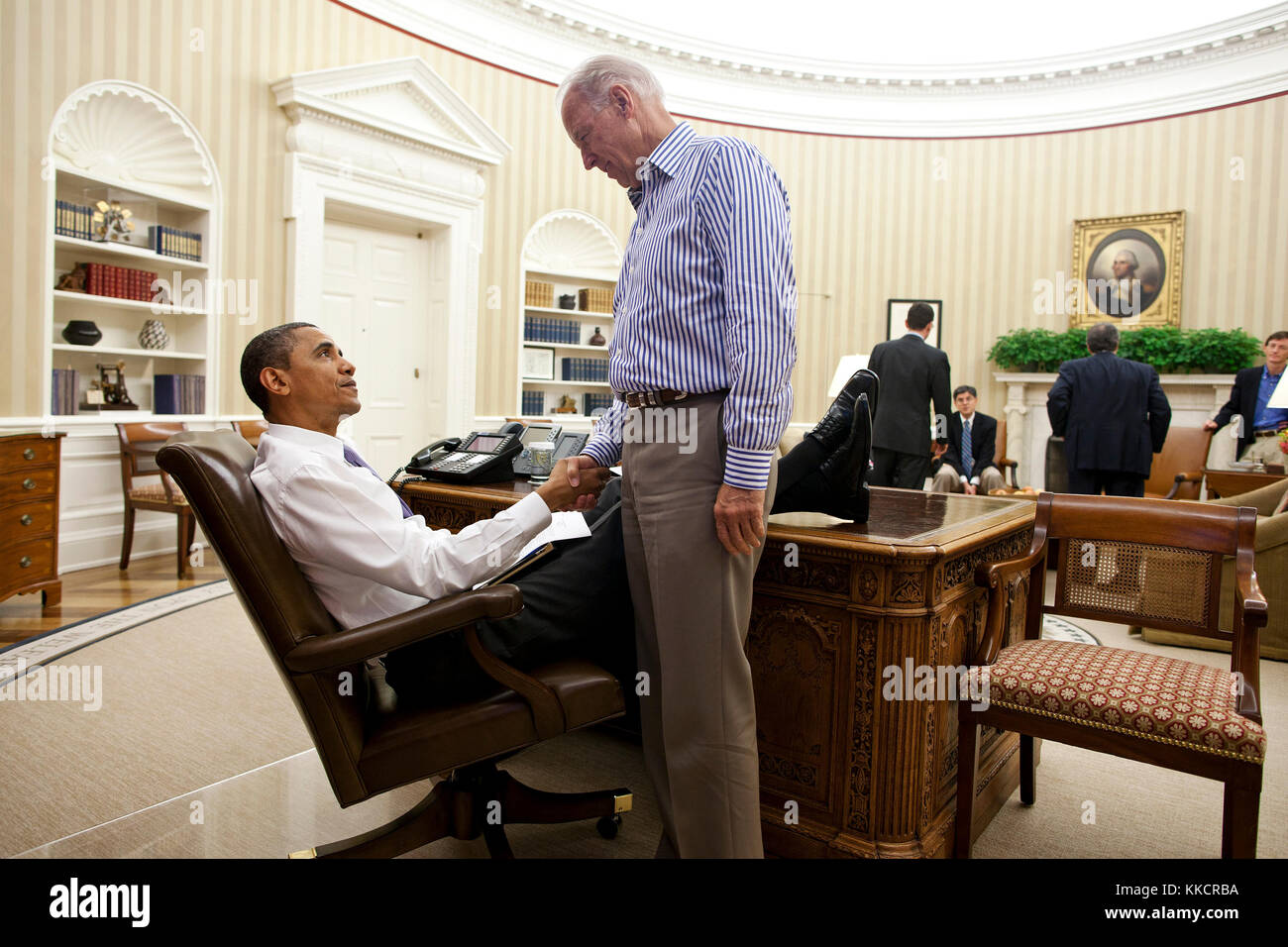 President Barack Obama and Vice President Joe Biden shake hands in the Oval Office following a phone call with House Speaker John Boehner securing a bipartisan deal to reduce the nation's deficit and avoid default, Sunday, July 31, 2011. Stock Photo