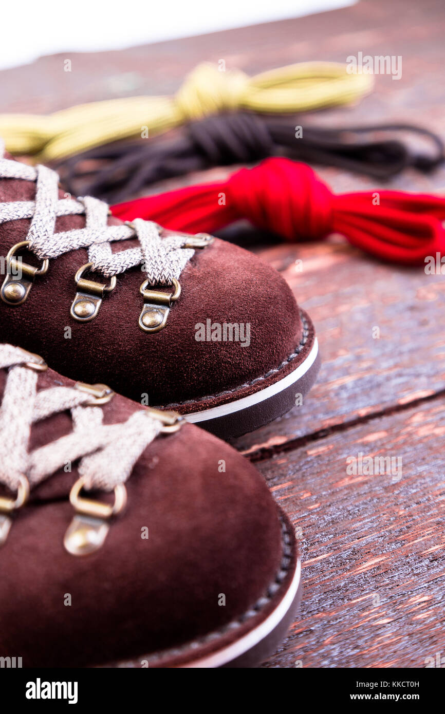Brown man suede boots and shoelaces on wooden background. Autumn or winter shoes. Macro Stock