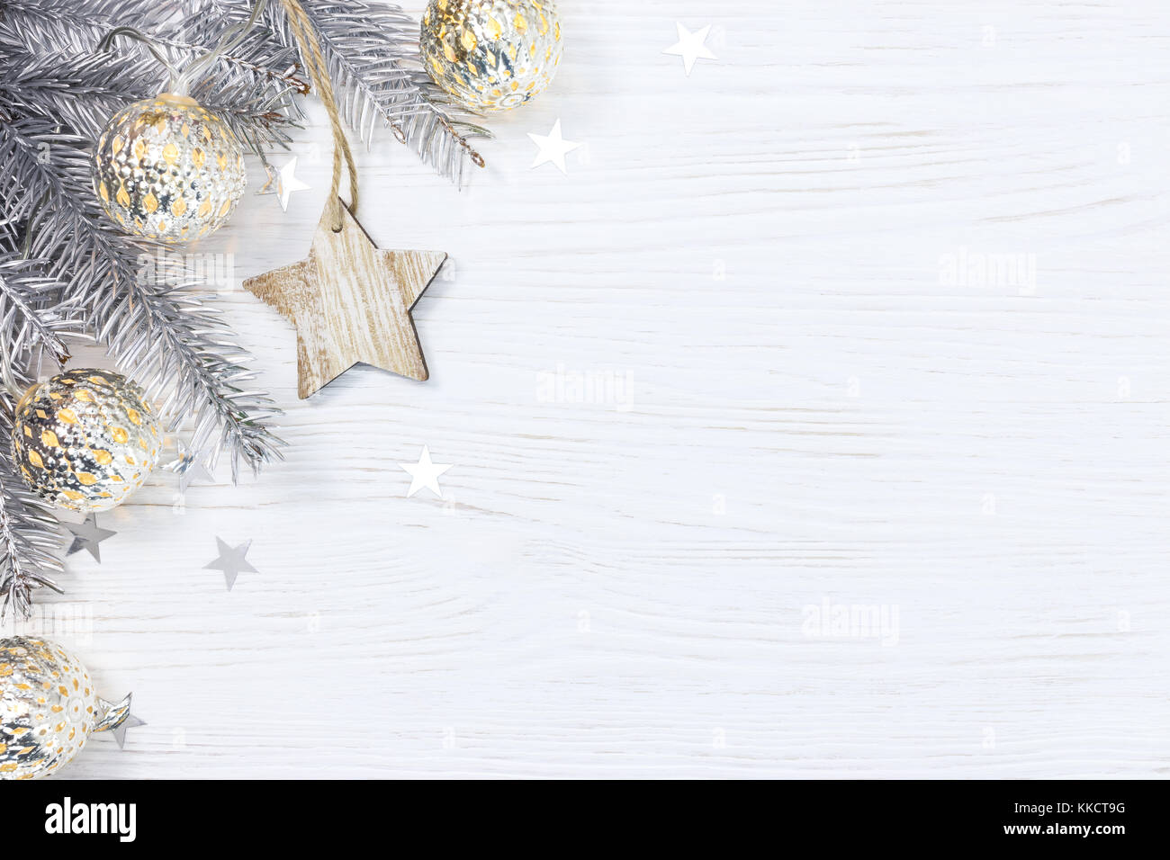 wooden star and silver christmas tree branch decorated with glowing ...