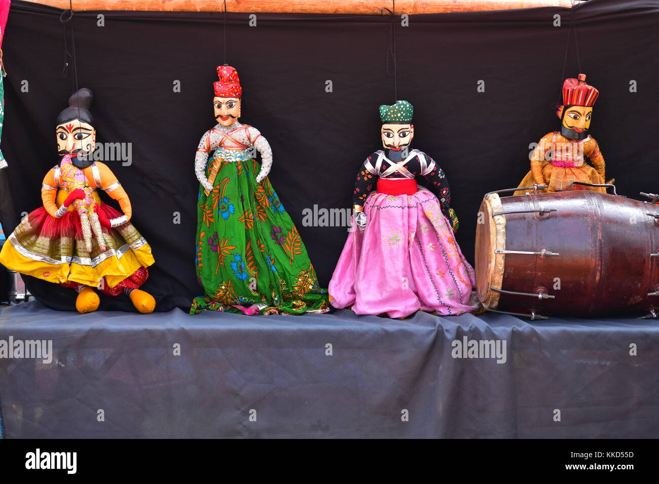 Four string puppets along with a traditional musical instrument called dholki on display at the National Crafts Mela, Kalagram, India. Stock Photo