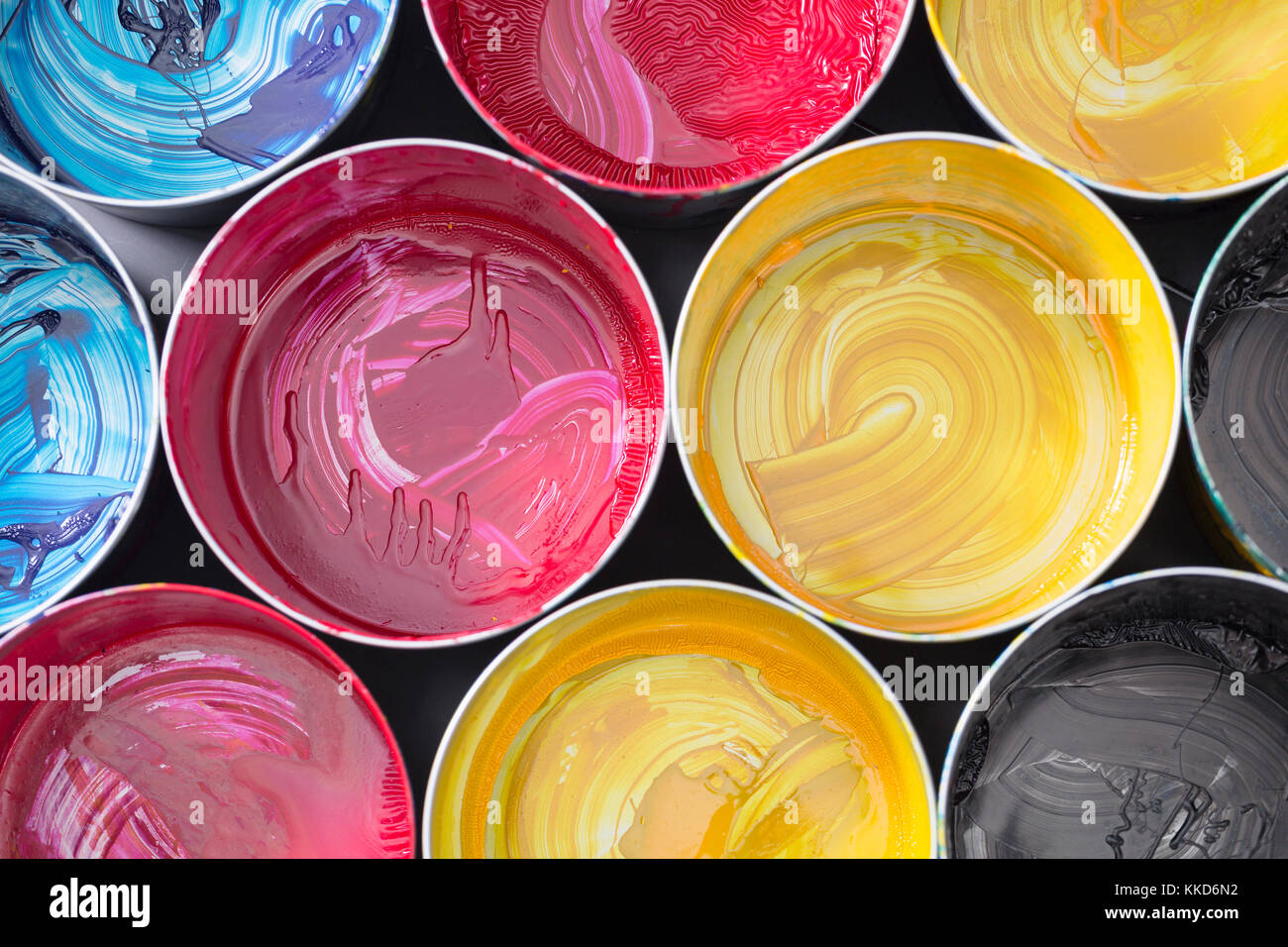 Top view of old CMYK paint cans on dark background. Colorful background ...