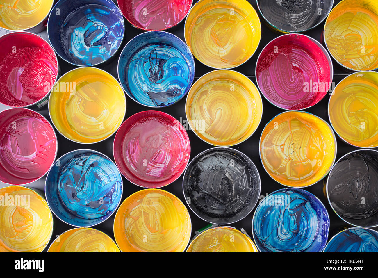 Top view of old CMYK paint cans on dark background. Colorful background ...