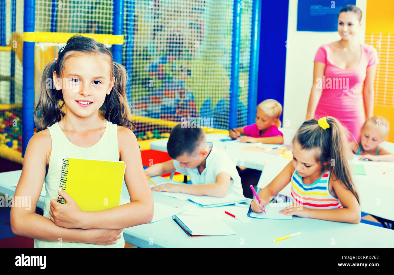 Portrait of cheerful diligent pupil girl studying in school class Stock ...