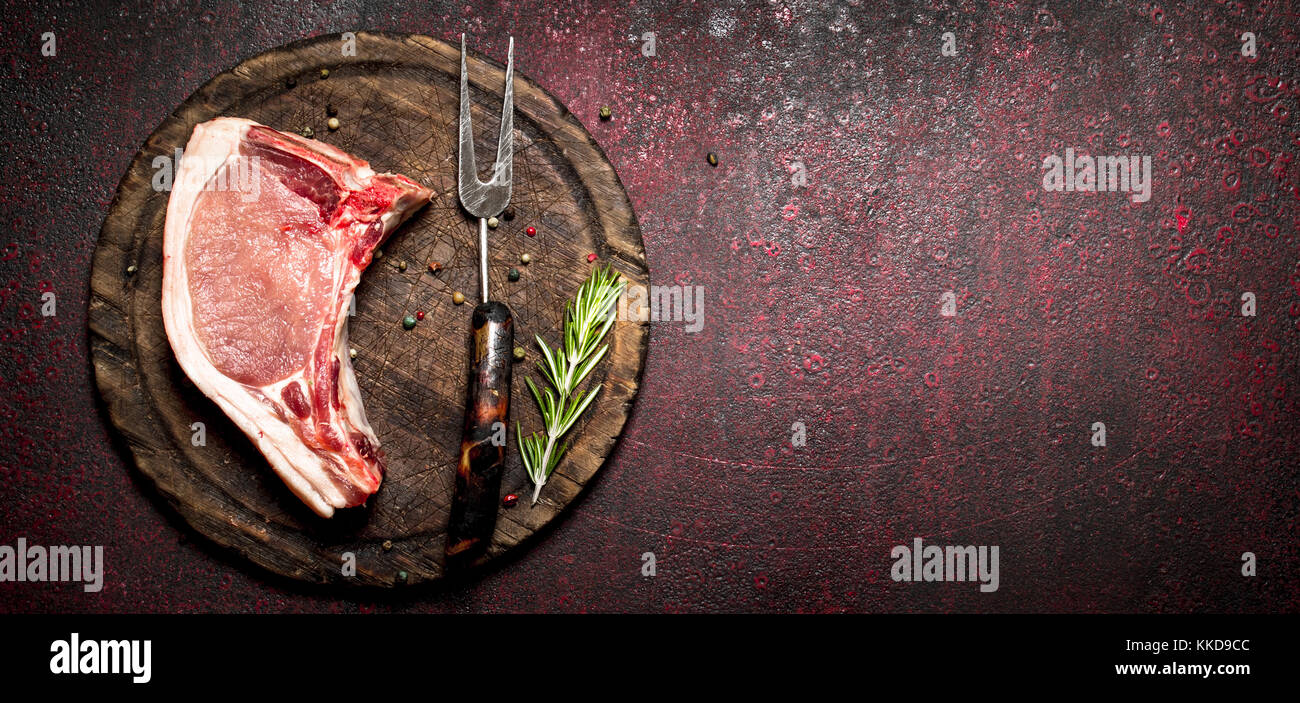 Raw meat background. Raw piece of pork with a sprig of rosemary. On ...