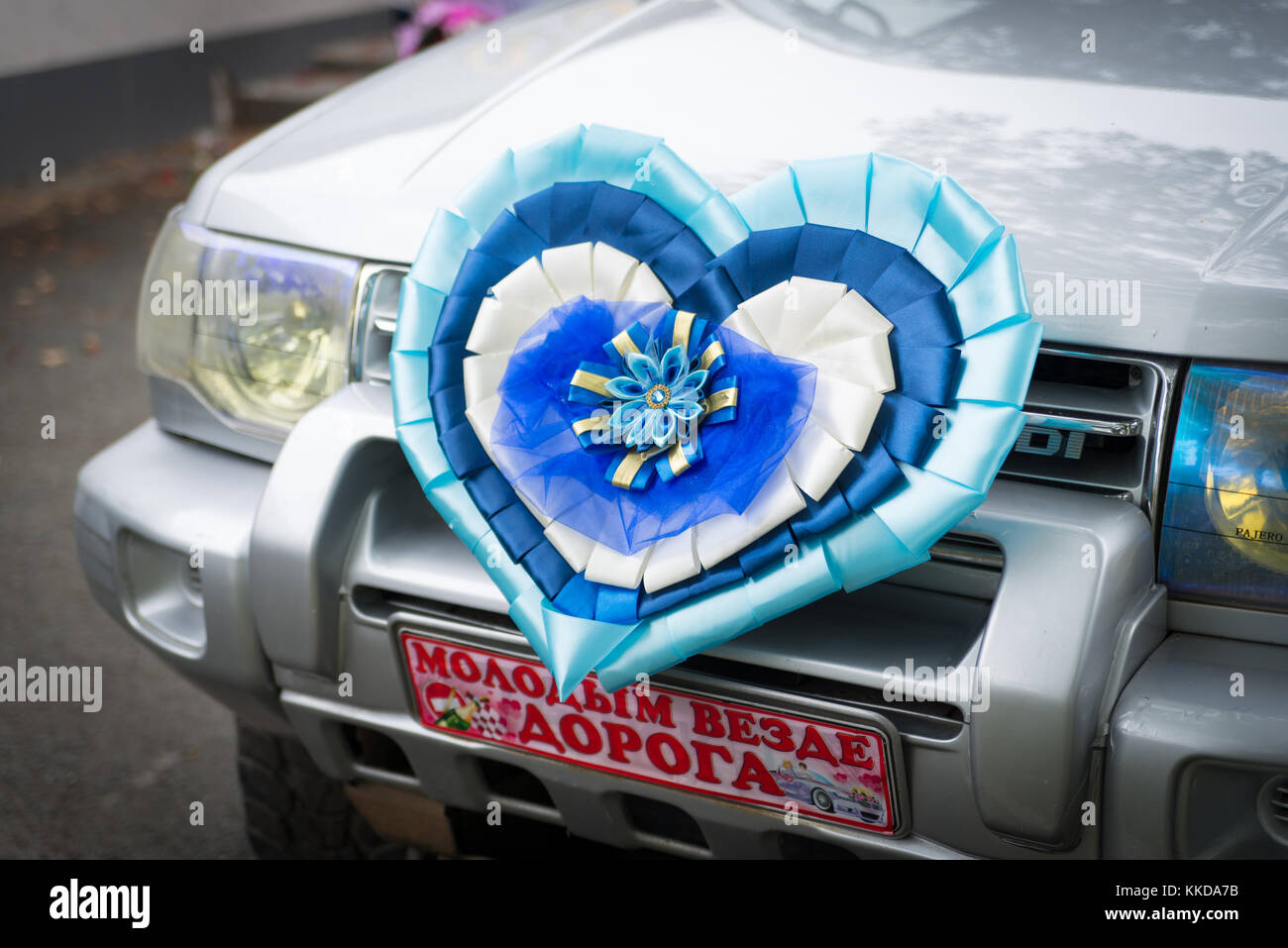 Wedding car with just married sign written on russian language and decorated heart on bumper. Stock Photo