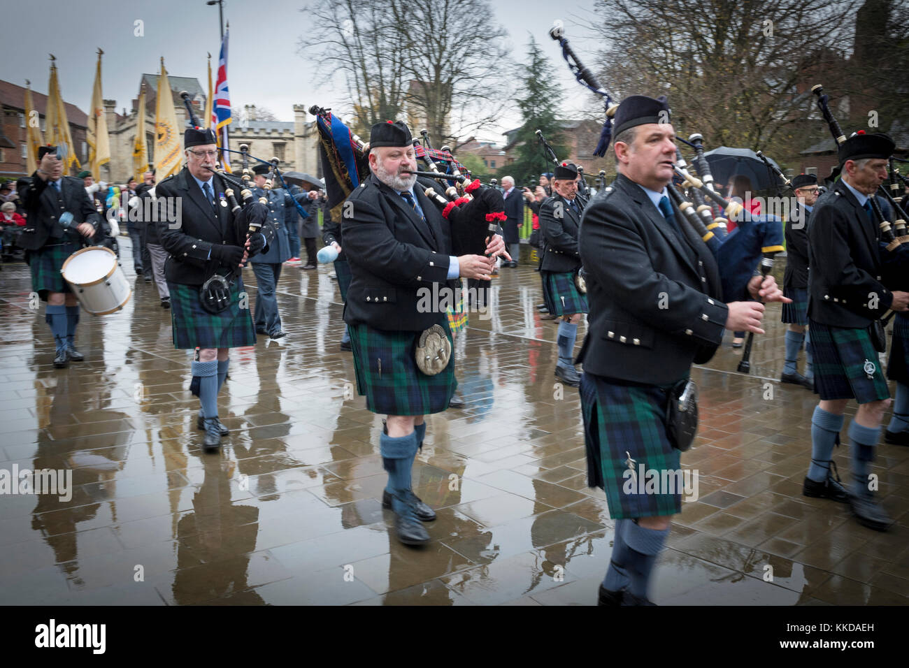 Pipe band marching & playing in rain during parade near York Minster on
