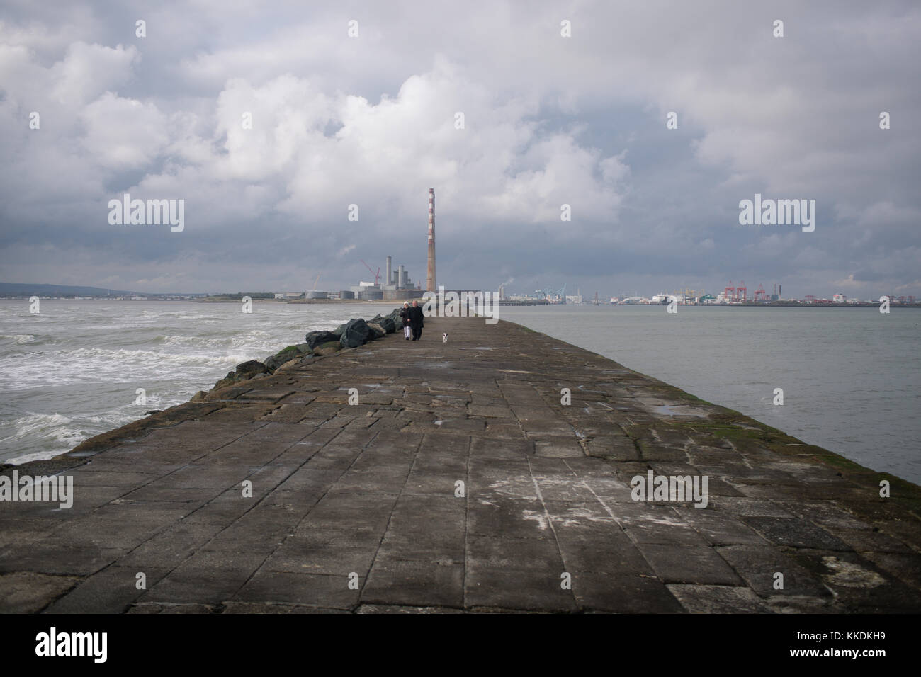 Couple walking on the Great South Wall at the Dublin Port with Poolbeg