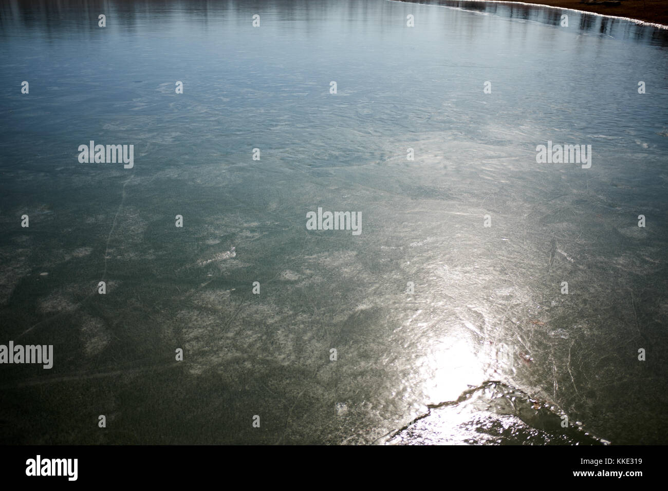 Frozen ice on a lake or river lit by a light to show the texture of the ...