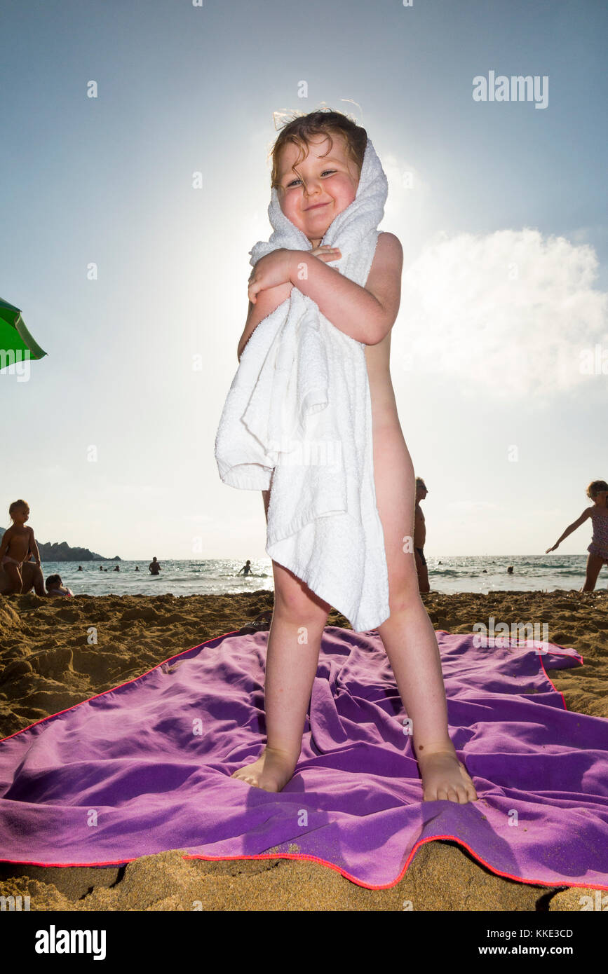 Girl / children / kids / kid  drying herself with a towel after swimming in the sea, at Golden Bay Beach, near Mellieha. Malta. (91) Stock Photo